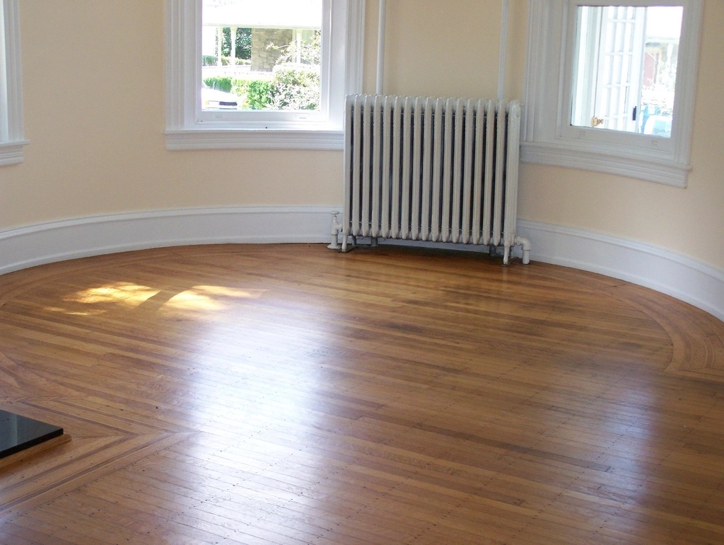 Ambiente vacío con piso de madera y ventanas