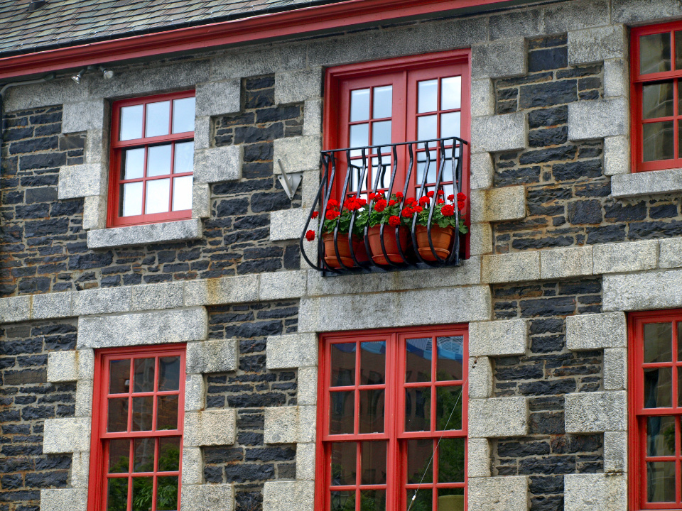 Fachada de piedra con ventanas rojas